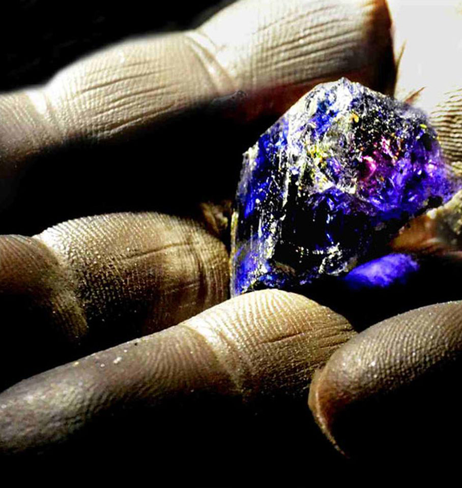 Hand holding a large rough Tanzanite gem stone 